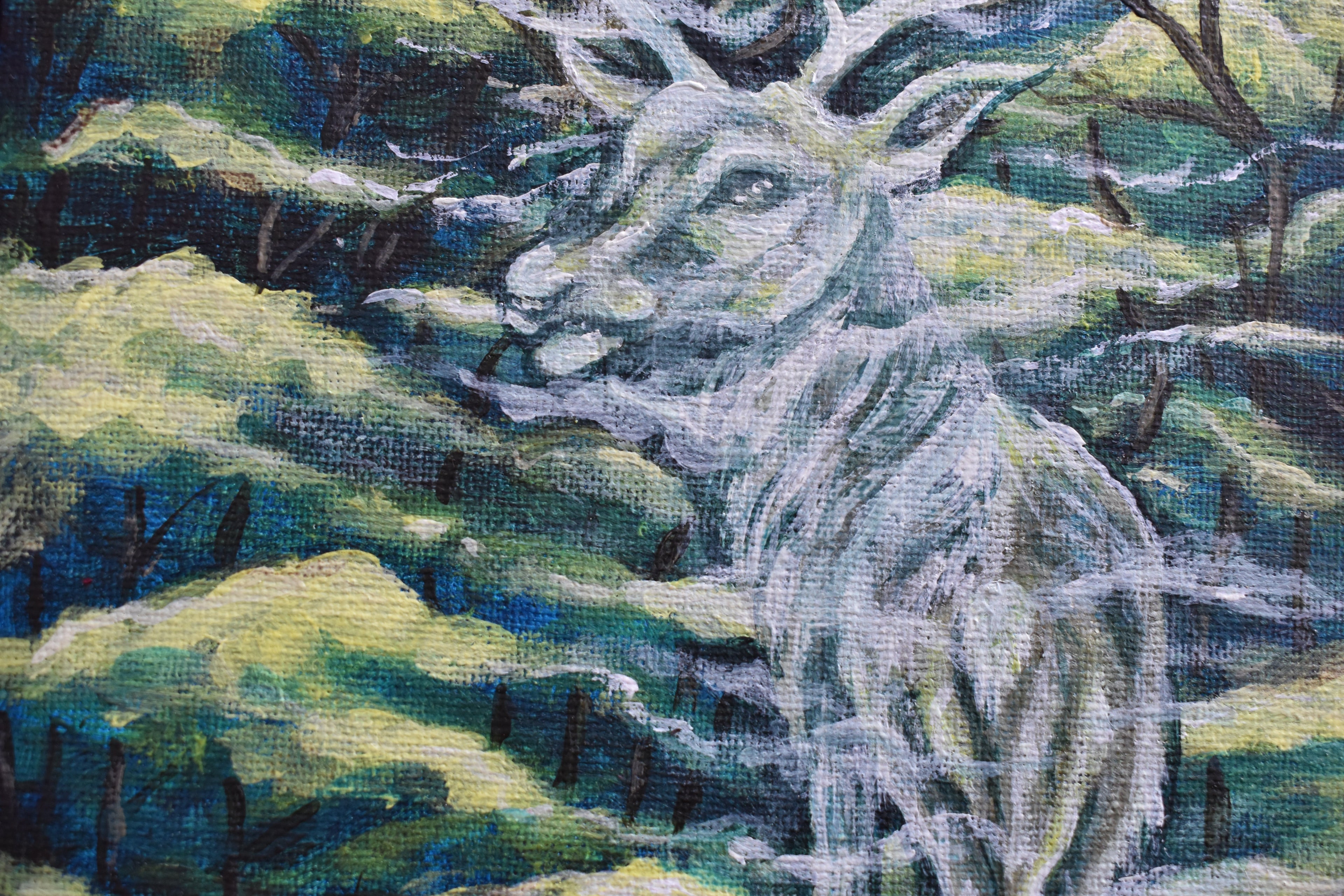 Close-up of a needlepoint or cross-stitch piece depicting a deer in a natural setting.